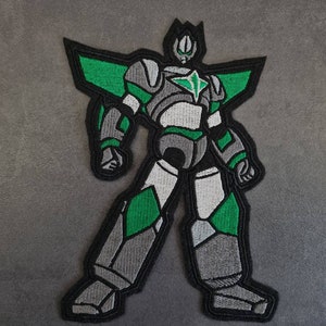 Puede incluir: Un parche bordado de un robot verde y gris con una estrella en el pecho.