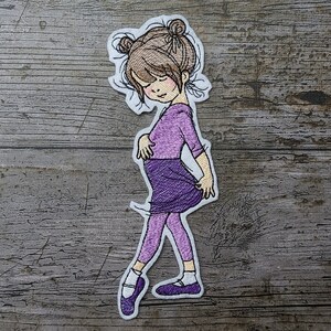 Puede incluir: Parche bordado para planchar de una niña con un leotardo y una falda morados, cabello castaño y zapatos de ballet morados.