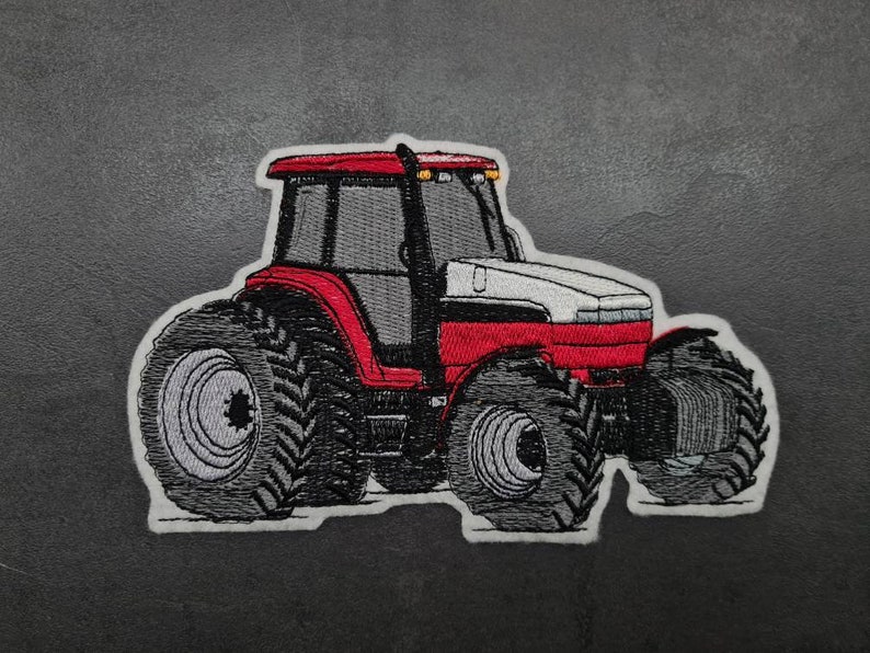 May include: Red and white tractor with large tyres, embroidered patch.