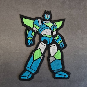 Puede incluir: Un parche bordado de un robot azul y verde con una estrella en el pecho.