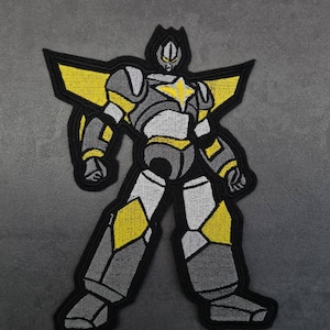 Puede incluir: Parche bordado termoadhesivo con un robot gris y amarillo con una estrella en el pecho.