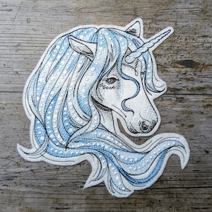 Peut inclure: Patch brodé représentant une tête de licorne bleue et blanche avec une corne argentée et un design détaillé. La licorne a une crinière et une queue bleues avec des points blancs.