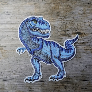 May include: Blue embroidered iron-on patch of a Tyrannosaurus Rex dinosaur.