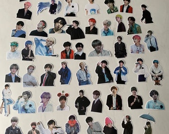 May include: A collection of 50 stickers featuring various images of a popular K-pop boy band. The stickers are printed on white paper and have a glossy finish.