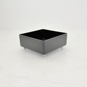 May include: A set of three ceramic mugs with a speckled, matte finish. The mugs are in shades of cream, light gray, and dark gray. Each mug has a simple, minimalist design, perfect for coffee or tea.