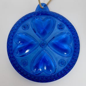 Puede incluir: Una taza de cerámica blanca con un asa negra y el texto "But First, Coffee" en un estilo manuscrito. La taza está sobre una superficie blanca. La taza mide aproximadamente 10 cm de alto.