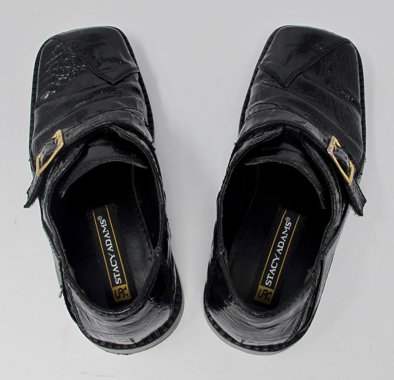 May include: A pair of black leather shoes with a buckle strap and the text "Stacy Adams" on the inside.