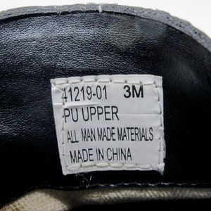 May include: A white label with black text that reads "41219-01 3M PU UPPER ALL MAN MADE MATERIALS MADE IN CHINA".