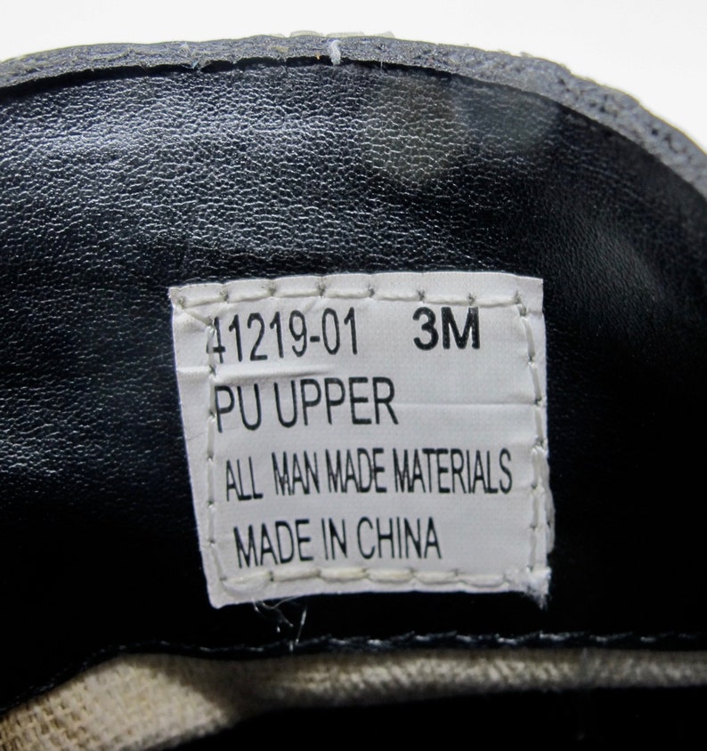 May include: A white label with black text that reads "41219-01 3M PU UPPER ALL MAN MADE MATERIALS MADE IN CHINA".