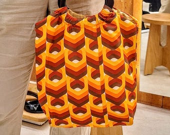 Torebka w stylu retro z drewnianymi uchwytami, wykonana z drukowanej bawełny.