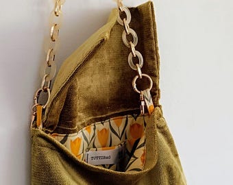 Zielona torba typu szenilowego, pasek w kolorze złotym i naturalnym łańcuszkiem.