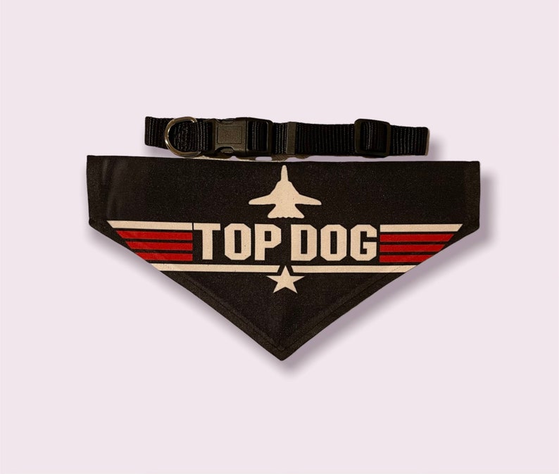 May include: Black dog bandana with a white "Top Dog" logo and a red, white, and blue fighter jet graphic. The bandana is attached to a black adjustable collar.