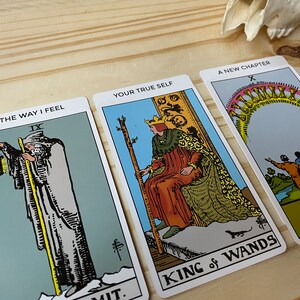 May include: Three tarot cards, "The Way I Feel" with the IX of Swords card, "Your True Self" with the King of Wands card, and "A New Chapter" with the X of Cups card.