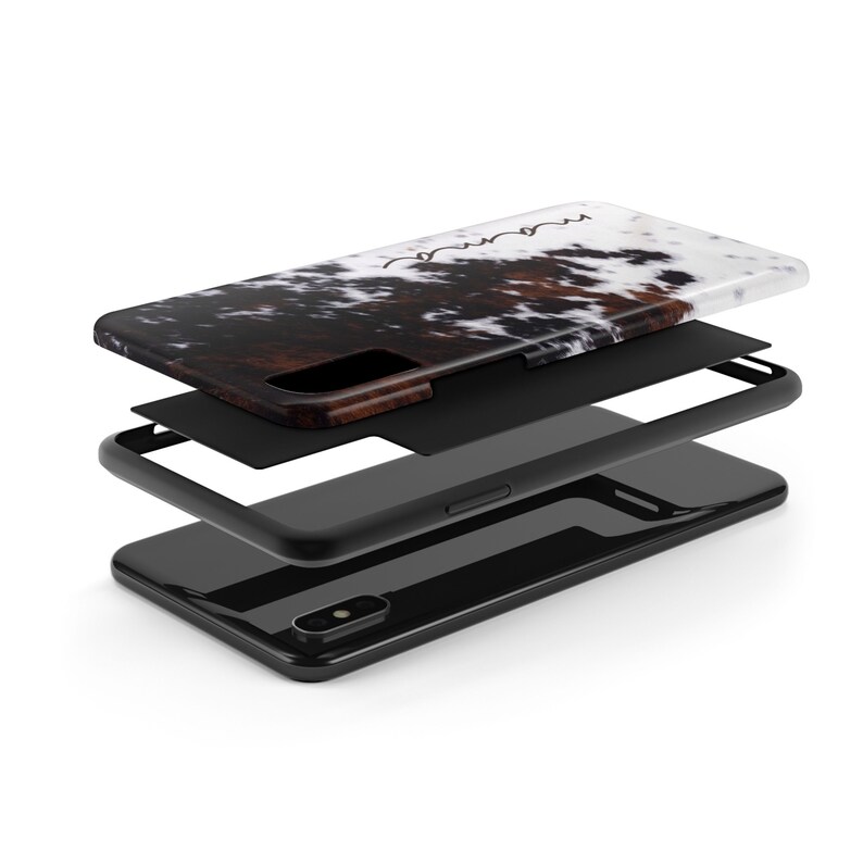 May include: A black phone case with a white and brown cowhide pattern. The case is shown in three layers, revealing the phone case, a black protective layer, and the phone itself.
