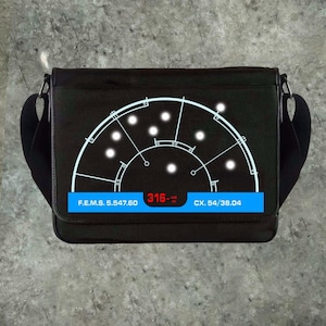 May include: Black messenger bag with a white radar-style graphic on the front. The graphic includes a series of white dots and lines. A blue bar at the bottom displays white text and red numbers. The bag has a black shoulder strap.
