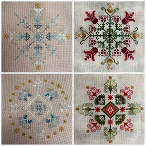 Puede incluir: Cuatro patrones de punto de cruz con diferentes diseños. El patrón de la parte superior izquierda es un copo de nieve con acentos azules y blancos. El patrón de la parte superior derecha es un diseño floral con acentos rojos, verdes y amarillos. El patrón de la parte inferior izquierda es una forma de diamante con acentos azules y blancos. El patrón de la parte inferior derecha es un diseño floral con acentos rojos, verdes y amarillos.