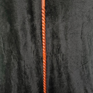 Op de afbeelding: Een houten wandelstok met een gebogen handvat en een gedraaide schacht. De stok is bruin van kleur met een messing accent bij het handvat. De stok heeft een rubberen dop.