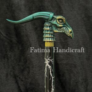 Peut inclure: Canne décorative avec une poignée en forme de tête de dragon verte et dorée. La tige noire est ornée d'éclairs blancs. Le texte "Fatima Handicraft" est imprimé sur la tige. Un accessoire orné et original.
