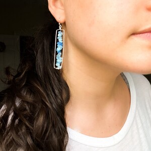 Puede incluir: Pendientes de plata con un marco rectangular y un degradado de piedras preciosas azules.