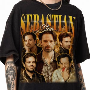 May include: Black t-shirt with a vintage-style graphic of Sebastian Stan. The graphic features four images of Stan in different poses, with the text "Sebastian Stan" in large, yellow letters and "Stan" in smaller, yellow letters.