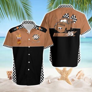 May include: Brown and black button-up shirt featuring a cartoon image of Tow Mater from the movie Cars. The shirt has a checkered pattern on the collar and sleeves, with the number 95 and the name "Tow Mater" printed on the front.