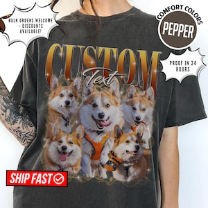 May include: Dark gray t-shirt featuring a custom design with five corgi dogs. The word "CUSTOM" is arched across the top in a gold gradient font, with the word "Text" below. The shirt has the words "COMFORT COLORS" and "PEPPER" printed on it.