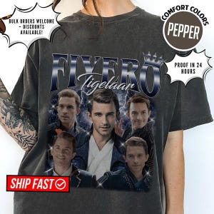 May include: Dark gray t-shirt featuring a graphic of a man with the text "FIYERO Tigelaar" in a stylized font. The shirt has additional text and graphics, including "COMFORT COLORS" and "PROOF IN 24 HOURS".