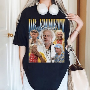 May include: Black t-shirt with a vintage-style graphic of Dr. Emmett Brown from the Back to the Future movie franchise. The graphic features multiple images of Dr. Brown in different scenes from the movie.