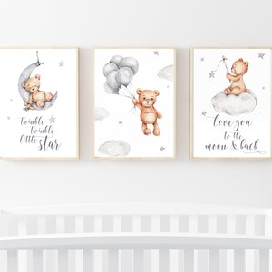 May include: Three watercolor prints featuring a brown teddy bear. The first print shows the bear sleeping on a crescent moon with the text "twinkle twinkle little star". The second print shows the bear holding balloons with stars in the background. The third print shows the bear sitting on a cloud with a star and the text "love you to the moon & back".