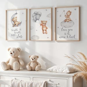 May include: Three framed prints with watercolor illustrations of teddy bears. The first print features a teddy bear sleeping on a crescent moon with the text "Twinkle twinkle little star". The second print features a teddy bear holding balloons with stars in the background. The third print features a teddy bear sitting on a cloud with the text "Love you to the moon & back".