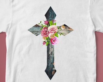 Peut inclure: T-shirt blanc avec un motif de croix florale. La croix est en bois avec une finition peinte bleu et blanc. Les fleurs sont roses, blanches et jaunes.