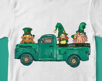 Peut inclure: Un t-shirt blanc avec un camion vert transportant trois lutins. Les lutins portent des chapeaux verts et tiennent des mugs de bière. Le camion a une cabine verte et une benne blanche.