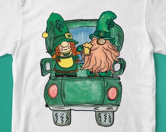 Peut inclure: T-shirt blanc avec un motif de camion vert représentant deux gnomes de dessin animé portant des chapeaux verts et tenant une bière. Les gnomes conduisent le camion avec les mots "Joyeux Saint-Patrick" écrits à l'arrière.