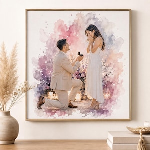 Pode incluir: Uma impressão de arte de parede quadrada emoldurada com uma ilustração em aguarela de uma pessoa ajoelhada para pedir outra em casamento. A cena é definida contra um fundo abstrato rosa e roxo com velas brilhantes e detalhes florais.