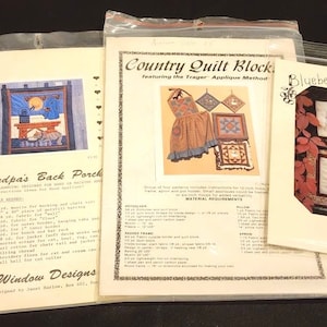 May include: Three packaged quilt patterns. One is titled "Grandpa's Back Porch" with a picture of a quilt. Another is "Country Quilt Block" with a picture of an apron and quilt blocks. The third is "Blueberry Backroads" with a picture of a fall scene.