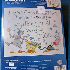 May include: Cross-stitch kit featuring a whimsical design with the text "I HATE FOUR LETTER WORDS" and the words "IRON, DUST, WASH, COOK!". The design includes a cartoon mouse and a yellow pot. The design size is 10" x 8".