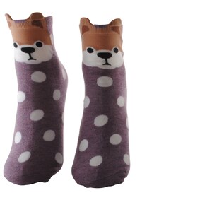 May include: A pair of purple socks with white polka dots and a brown dog face on the top of each sock.