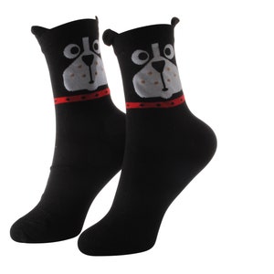 May include: A pair of black socks with a white and gray dog face design. The dog has a red collar.