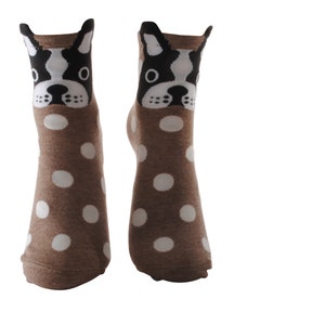 May include: A pair of brown socks with white polka dots and a black and white dog face design on the top of each sock.