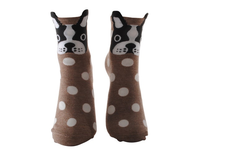 May include: A pair of brown socks with white polka dots and a black and white dog face design on the top of each sock.