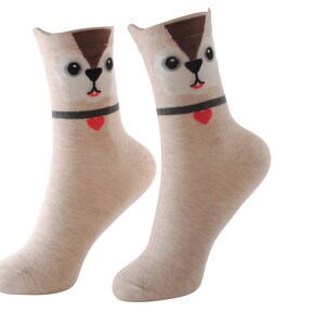 May include: A pair of beige socks with a cartoon squirrel face on the front. The squirrel has brown fur, black eyes, and a red heart on its collar.