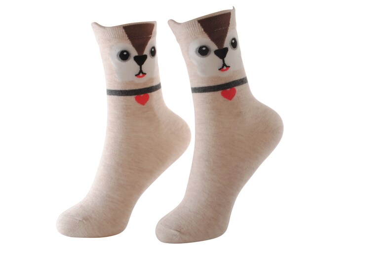 May include: A pair of beige socks with a cartoon squirrel face on the front. The squirrel has brown fur, black eyes, and a red heart on its collar.