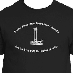 May include: Black t-shirt with a white graphic of a guillotine and the text "French Revolution Reenactment Society Get In Line with the Spirit of 1789!"
