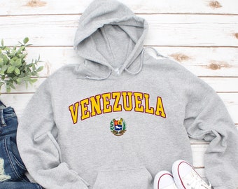 May include: Gray hooded sweatshirt with the word "VENEZUELA" in yellow letters with a red outline and a small coat of arms in the center.