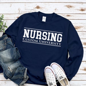 May include: A navy blue sweatshirt with white text that reads "Nursing Custom University".