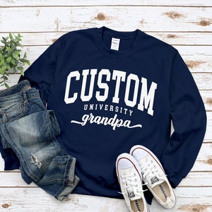 May include: Navy blue sweatshirt with white text that reads "CUSTOM UNIVERSITY grandpa".