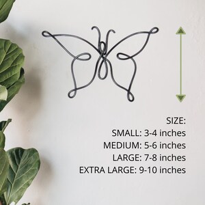 May include: A black metal butterfly wall decor in various sizes.  The butterfly is made of wire and has a delicate, intricate design.  The sizes are: Small: 3-4 inches, Medium: 5-6 inches, Large: 7-8 inches, Extra Large: 9-10 inches.