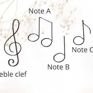 May include: A set of black metal music note and treble clef ornaments. The notes are labelled "Note A", "Note B", and "Note C".