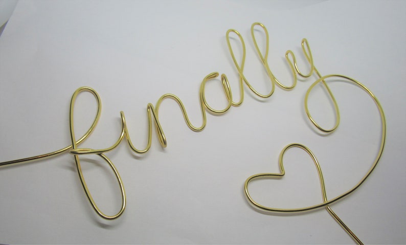 May include: Gold wire sculpture of the word "finally" with a heart at the end.