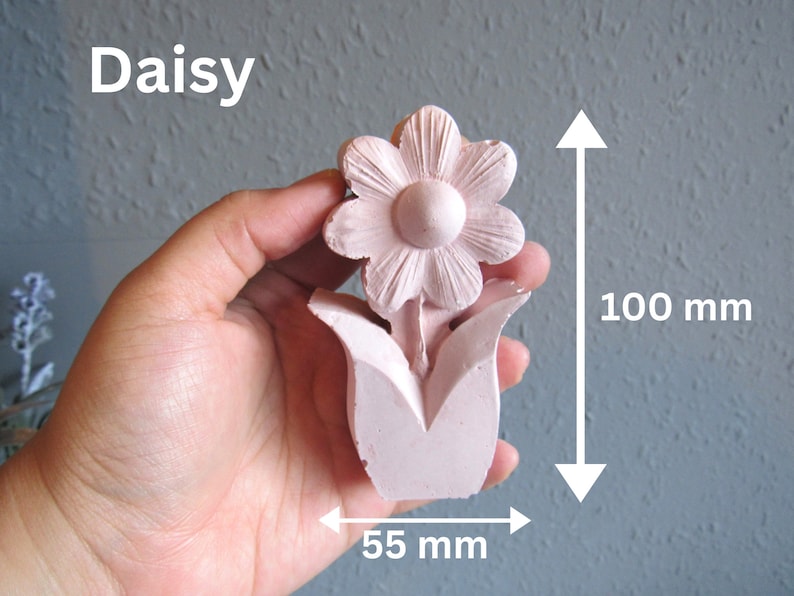 K&ouml;nnte beinhalten: Eine rosa Keramik-G&auml;nsebl&uuml;mchen-Blume mit f&uuml;nf Bl&uuml;tenbl&auml;ttern und einem Mittelkreis. Die Blume ist 10 cm hoch und 5,5 cm breit.